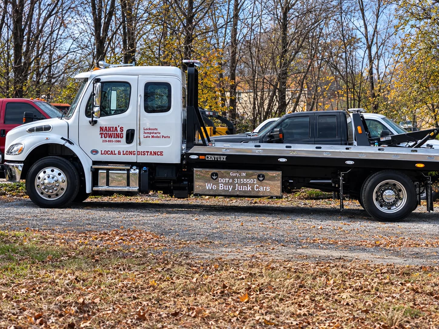 Nakia's Towing flatbed tow truck carrying a pickup