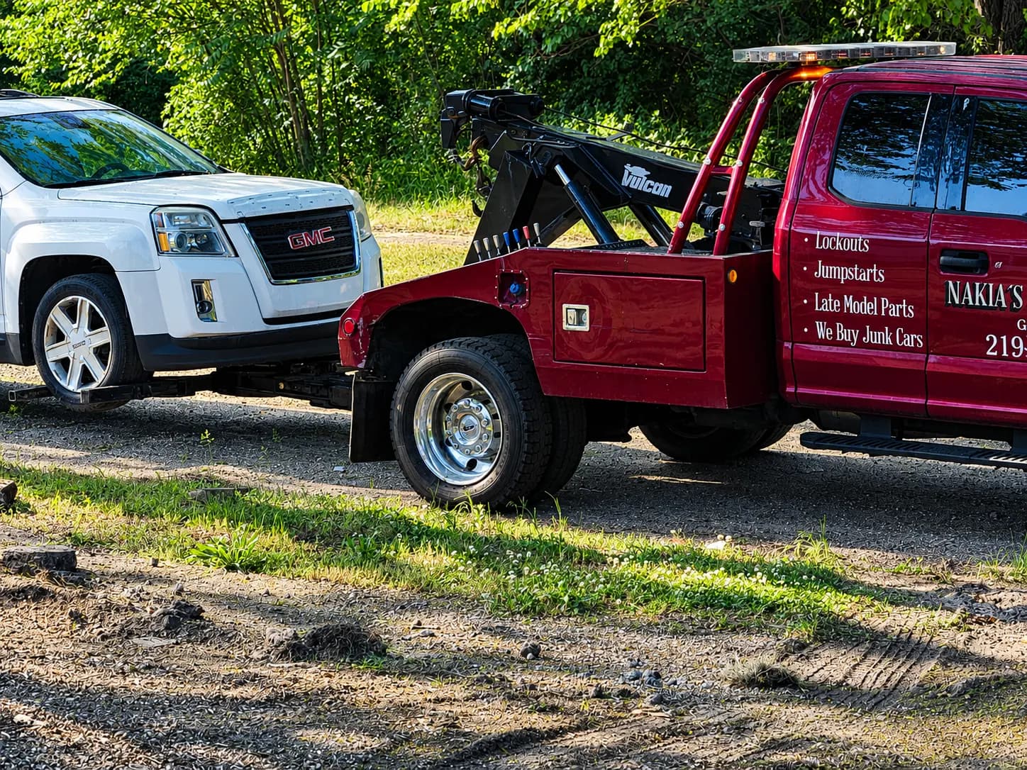 Nakia's wrecker towing a white SUV by its front wheels