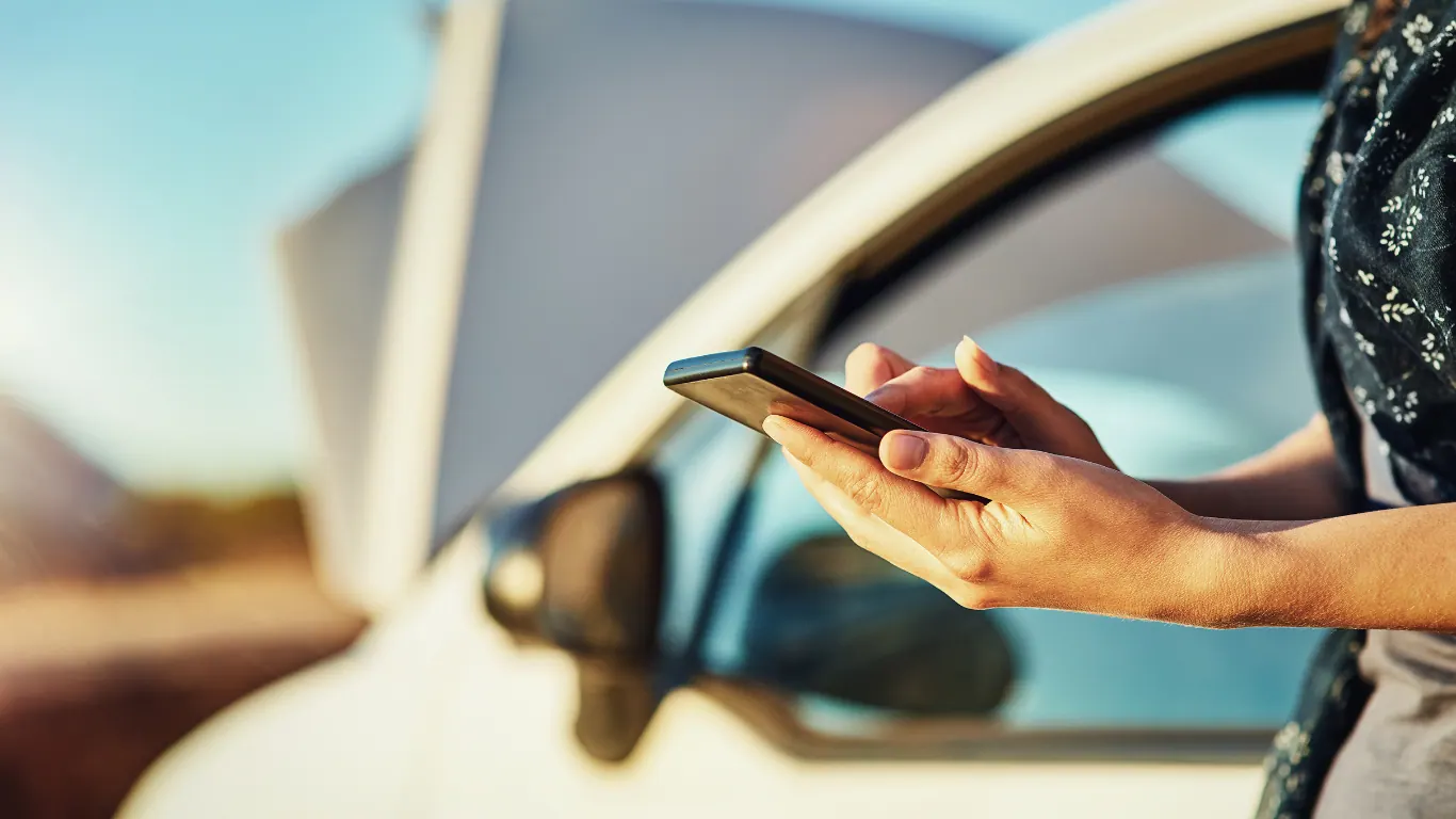 Driver holding a phone beside a locked car